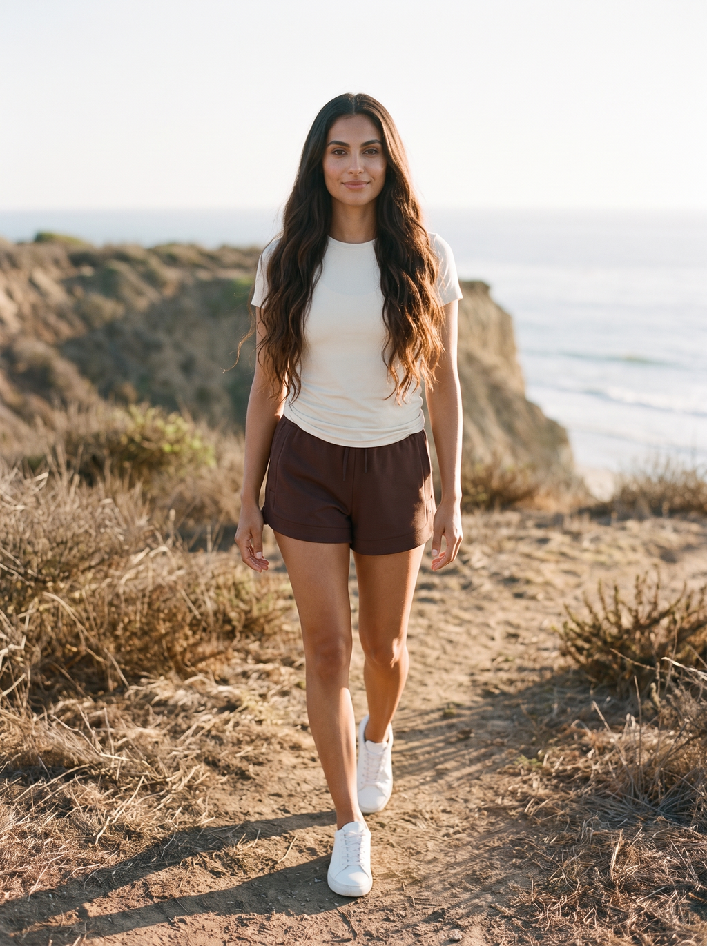 Rhone DreamGlow Short 3 inch in Dark Espresso with a cream tee, on a Southern California coastal bluff