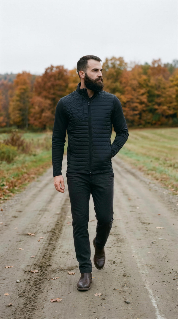 Greyson Yukon Hybrid Jacket in Shepherd black, walking a dirt farm road outside Stowe, Vermont in mid-October.